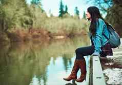 水令人惊异的拍摄年轻的女人坐着湖在户外