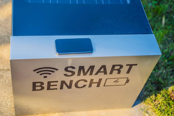 聪明的板凳上当地的公共公园充电移动手机提供无线网络