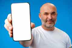 中年男人。显示空白智能手机屏幕复制空间蓝色的背景
