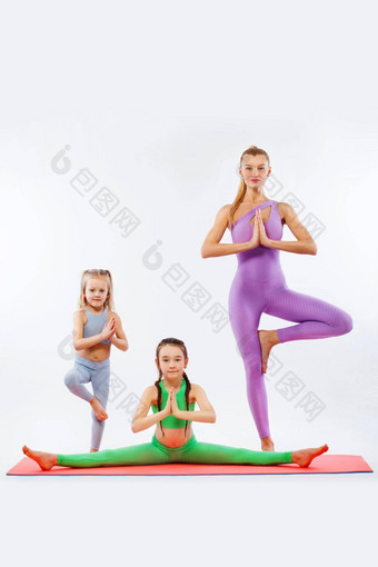 哈达瑜伽<strong>健身</strong>年轻的妈妈。教练女儿锻炼体操孤立的白色背景家庭