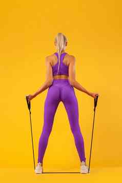 健身女人运动员健美运动员持有扩张器孤立的黄色的背景