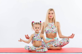 哈达瑜伽<strong>健身</strong>年轻的妈妈。女儿锻炼在室内家庭