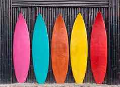彩色的冲浪板倾斜木栅栏
