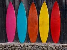 彩色的冲浪板倾斜木栅栏