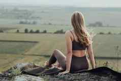回来视图年轻的女人坐着前山健康的女孩实践瑜伽在户外全景景观日落
