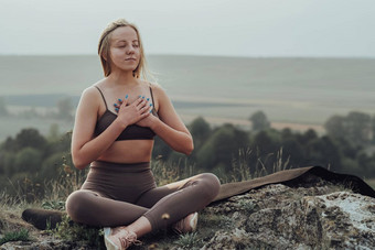 年轻的女人实践瑜伽在户外全景景观日落运动女孩冥想练习前山