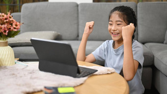 快乐亚洲孩子坐着生活房间学习在线虚拟类电脑平板电脑电子学习教育概念