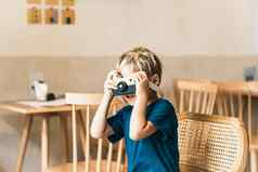 可爱的快乐微笑男孩玩手工制作的木照片相机持有玩具手艺术工艺活动学前教育孩子们发展技能未来有创意的职业现代舒适的类房间