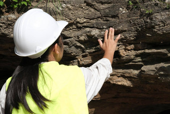 亚洲女地质学家研究员触摸岩石手分析表面自然公园探索地质学家场石头生态概念