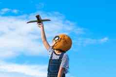 可爱的女孩运行草地阳光明媚的一天玩具飞机手快乐孩子玩纸板飞机蓝色的夏天天空背景童年梦想想象力概念