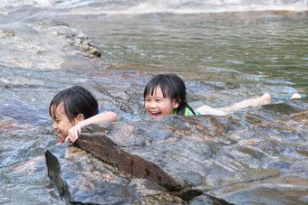 可爱的亚洲孩子们穿生活夹克<strong>享受</strong>玩河姐妹<strong>享受</strong>游泳流健康的夏天活动孩子们