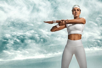 运动适合年轻的女人运动员放松培训沙漠多云的一天海岸概念健康的生活方式体育运动女人白色运动服装