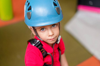可爱的女孩登山者蓝色的保护头盔齿轮攀爬站登山者中心娱乐公园孩子们