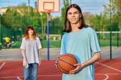 肖像年轻的的家伙玩篮球户外游戏法院女孩焦点