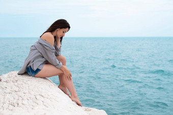 可爱的女孩夏天衣服白色岩石海海岸