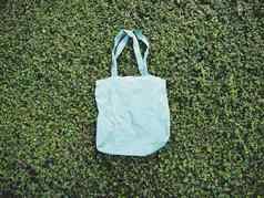 空白蓝色的模型亚麻棉花手提包袋绿色布什树树叶背景生态自然友好的风格环境保护回收概念模板艺术作品文本日本