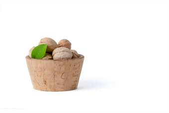 胡桃木胡桃木水果品种谎言木碟子篮子白色孤立的背景附近的绿色叶子生胡桃木水果