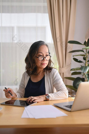 集中中间岁的女人穿眼镜工作<strong>首页</strong>移动PC管理国内账单<strong>首页金融</strong>