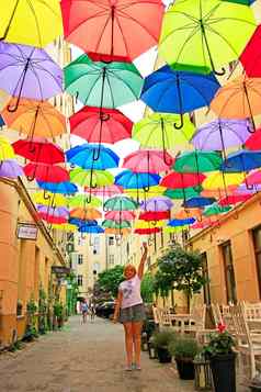 女人站彩色的雨伞挂前集伞