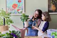 妈妈。女儿孩子护理房子花能女孩洒喷雾植物