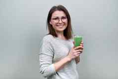 成熟的女人绿色蔬菜奶昔喝健康的素食主义者饮食