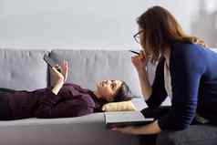 年轻的女人咨询心理学家女病人说谎沙发上
