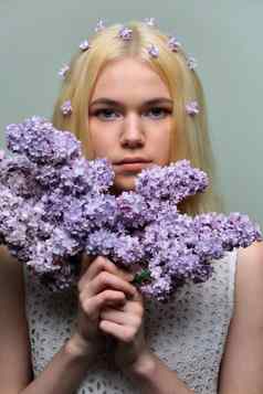 肖像年轻的青少年金发女郎女孩紫罗兰色的淡紫色花头发手