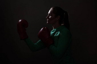 拳击女人绿色运动服装红色的拳击手套