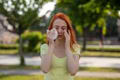 年轻的红发女人打喷嚏花粉过敏症状