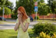 年轻的红发女人打喷嚏夏天花粉过敏症状