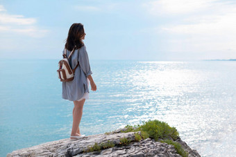 旅行者女孩夏天衣服时尚背包白色岩石海滨