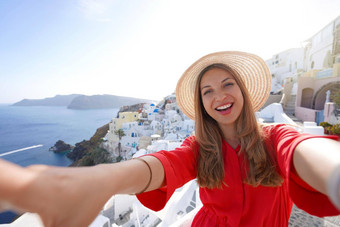 旅行者女孩采取自拍照片圣托里尼岛日落微笑女人有趣的aio村希腊