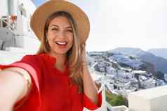 时尚旅行者女孩采取自拍照片aio风景如画的希腊村圣托里尼岛岛年轻的女人享受假期希腊欧洲