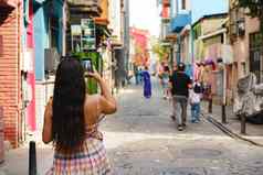 年轻的女旅游探索城市使照片智能手机