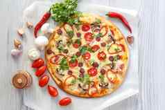 新鲜的自制的披萨西红柿意大利蒜味腊肠奶酪蘑菇