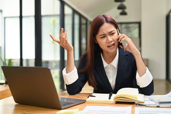 年轻的女办公室工人谈话移动电话争论客户端解决业务问题