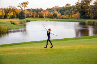 秋天湖高尔夫球年轻的成人女人运行