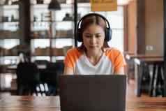 十几岁的亚洲女远程学生坐首页电脑参与虚拟事件遥远的教训自信年轻的混血儿女人耳机教研究外国语言在线