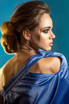 美肖像时尚的女人优雅的发型化妆蓝色的衣服