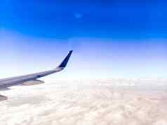 翼飞机蓝色的天空背景飞机翼飞行窗口蓝色的天空旅行概念的想法