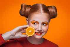 年轻的美丽的时尚模型橙色工作室拍摄