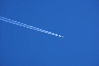 飞机<strong>航迹</strong>云清晰的蓝色的天空背景Copyspace视图遥远的乘客飞机飞机飞行高高度蓝色的天空离开长白色烟小道空气运输
