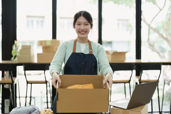 肖像小启动亚洲女企业家锻造老板挑选黄色的衬衫包装盒子客户在线业务的想法自由