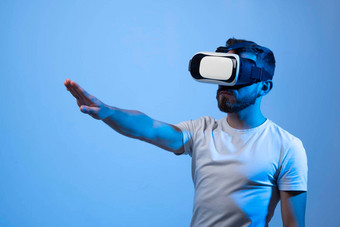 年轻的有胡子的男人。虚拟现实头盔戏剧在线游戏元宇宙游戏模拟行为虚构的世界小工具虚拟现实上瘾未来技术概念