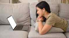 微笑年轻的女人放松生活房间会说话的在线虚拟闲谈，聊天电脑移动PC休闲活动技术概念