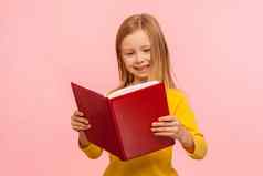 聪明的可爱的女孩阅读大红色的书微笑幸福的学习家庭作业好奇的