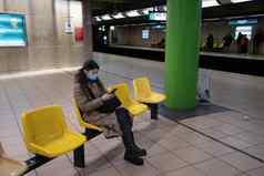 年轻的女人温暖的夹克绿色屏幕智能手机坐在地铁