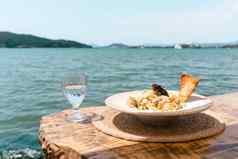 海鲜意大利面意大利面玻璃水站木表格咖啡馆餐厅风景海背景复制空白空间鱼潜水面条概念