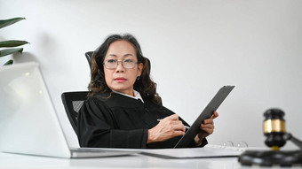 专业成熟的女律师签署文档移动PC工作场所律师正义法律律师概念
