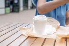 特写镜头女人吃快食物街咖啡馆模型白色咖啡杯